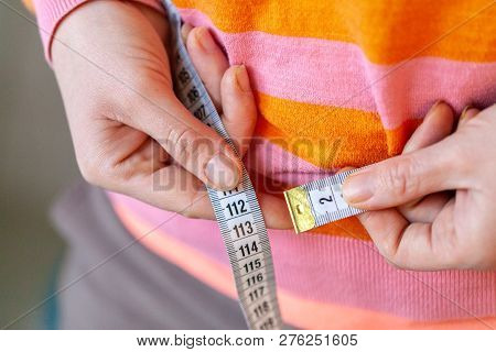 Woman Measures Her Abdomen With A Measuring Tape
