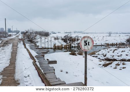 Old Wood Bridge Over Olt River At Wintertime In Romania   5 Ton Warning Street Sign.