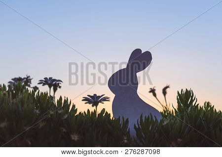 Creative Easter Photo Of Silhouette  Paper Rabbit In The Chamomile Flowers And Green Grass On The Su
