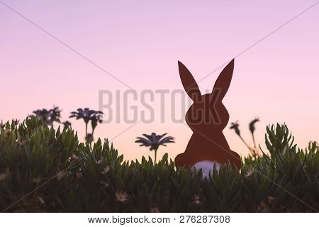 Creative Easter Photo Of Silhouette  Paper Rabbit In The Chamomile Flowers And Green Grass On The Su