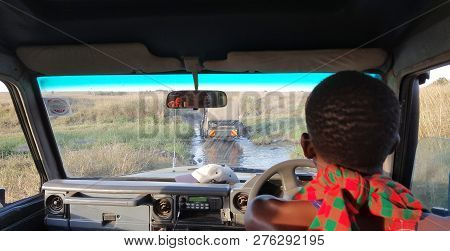 Masai Mara - Kenya / August 2018: Safari Driver Passing Through Muddy Trail.