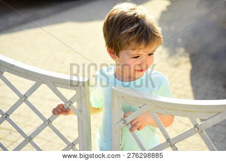 Safety Of Children. Portrait Of Cute Child Near White Garden Fence. Forbidden Place For Children. Cl