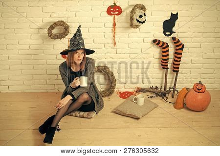 Halloween Woman In Witch Hat With Cups. Girl Sitting On Wooden Floor. Coffee Or Tea Break. Holiday C