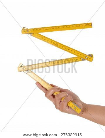 A Close Up Image Of A Hand Holding A European Yellow Wood Ruler A 
Zollstock, A Carpenter Tool, Isol