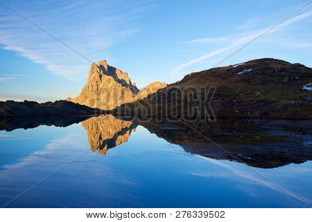 Midi Dossau Peak reflected in a lake. Ossau Valley, Pyrenees National Park, Pyrenees, France.
