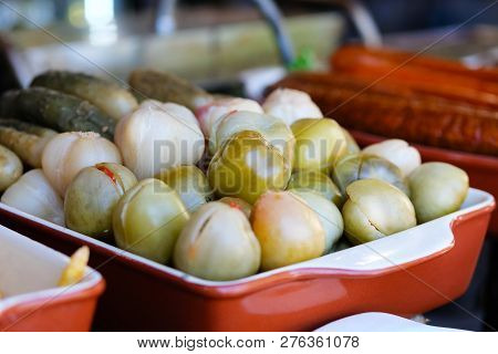 Pickled Green Tomatoes, Cucumbers And Garlic In Meat Market In The Street.street Food And Outdoor Co