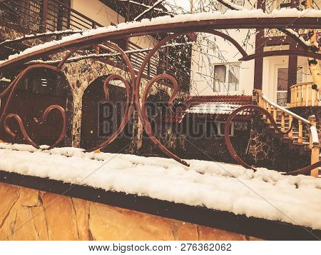 Srone Gate With Decorative Steel Trim. Snowfall On The Street.noon.