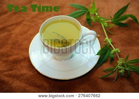 Marijuana Tea. Hemp Tea. Cannabis Tea with a Marijuana Leaf and Stem with Flowers and Leaves on a leather background.  Room for text. 


