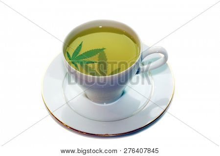Cannabis Tea. Marijuana Tea. Hemp Tea with a Marijuana Leaf in a white Tea Cup. Isolated on white. Room for text. 