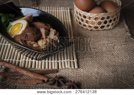 Stewed Eggs And Pork In Black Bowl And Spices Place In Front Of And Eggs Of Basket Place Backside On