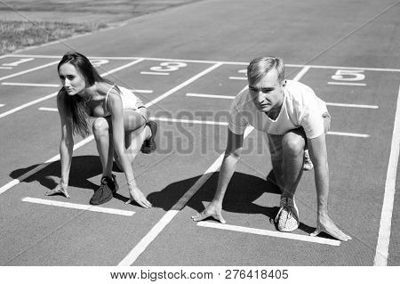 Man And Woman Low Start Position Running Surface Stadium. Running Competition Or Gender Race. Faster