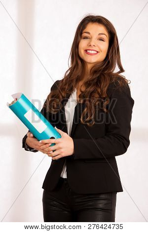 Beautiful Confident Business Woamn Holding A Folder In Her Hands In The Office