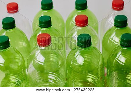 Many Green Plastic Bottles With Caps. Production Of Beverages In Plastic Containers. Problem Of Envi