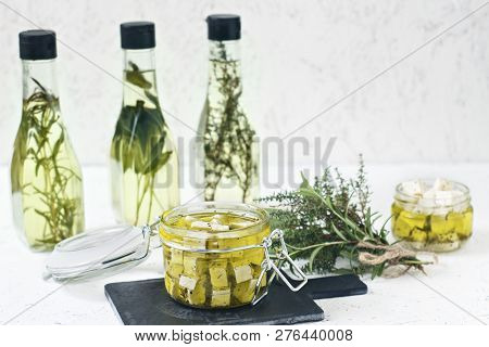 Marinated Feta In A Glass Jar, Spices And Flavored Olive Oil On A Wooden Background