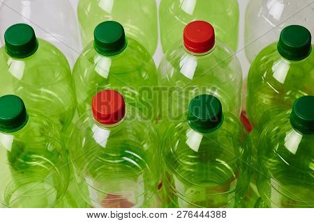 Many Green Plastic Bottles With Caps. Production Of Beverages In Plastic Containers. Problem Of Envi