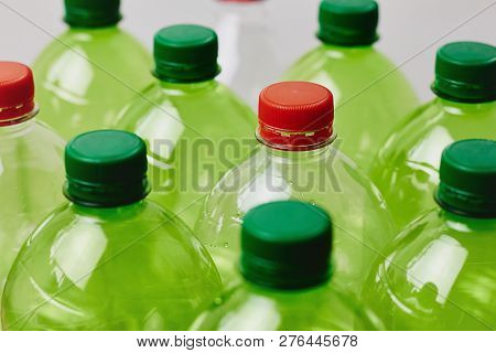 Many Green Plastic Bottles With Caps. Production Of Beverages In Plastic Containers. Problem Of Envi