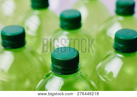 Many Green Plastic Bottles With Caps. Production Of Beverages In Plastic Containers. Problem Of Envi