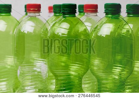 Many Green Plastic Bottles With Caps. Production Of Beverages In Plastic Containers. Problem Of Envi