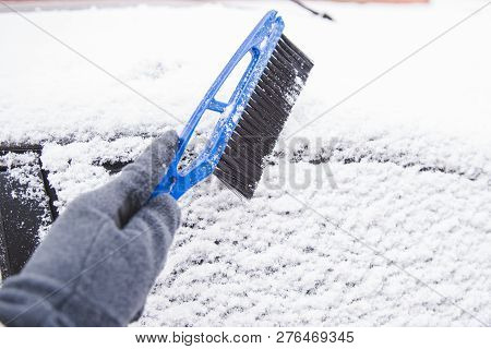 Man With Scrapper Cleaning Car Out Of Snow. Snow Storm