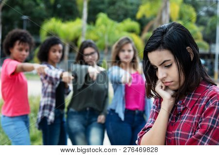 Group Of Girls Bullying An Arabic Young Adult Woman Without Friends Outdoors