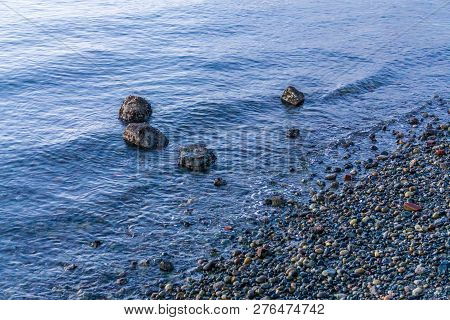 Rocks Are In The Water Near Shoew In West Seattle, Washington.