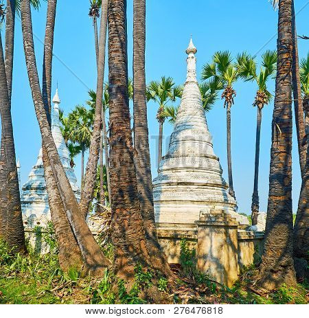 The Old White Pagodas Of Bagaya Monastery, Decorated With Relief Belts, Surrounded With Tall Palm Tr