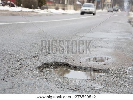 There Are Many Potholes On The Roadway Close Up