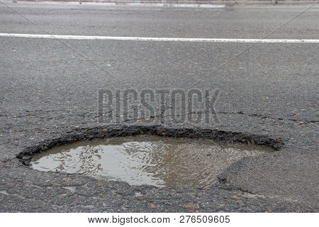 There Are Many Potholes On The Roadway Close Up