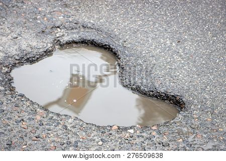 There Are Many Potholes On The Roadway Close Up