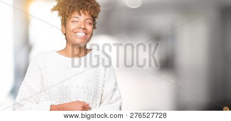Beautiful young african american woman wearing winter sweater over isolated background Smiling and laughing hard out loud because funny crazy joke. Happy expression.