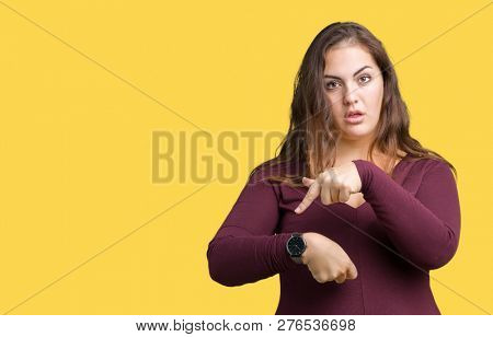 Beautiful and attractive plus size young woman wearing a dress over isolated background In hurry pointing to watch time, impatience, upset and angry for deadline delay