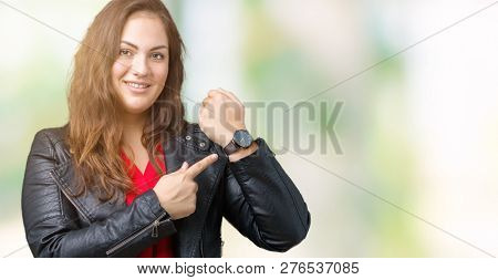 Beautiful plus size young woman wearing a fashion leather jacket over isolated background In hurry pointing to watch time, impatience, upset and angry for deadline delay