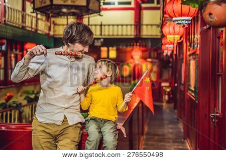 Enjoying Vacation In China. Happy Tourists Dad And Son With A Chinese Flag And With Traditional Chin