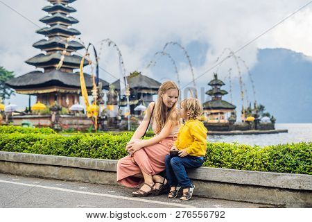 Mom And Son In The Background Of Pura Ulun Danu Bratan, Bali. Hindu Temple Surrounded By Flowers On 