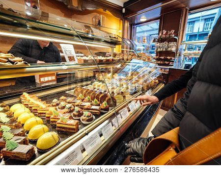 Strasbourg, France - Dec 29, 2018: Senior Woman Pointing To Sweets In Traditional French Pastry Stor