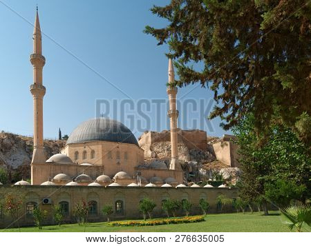 URFA, TURKEY - AUGUST 19, 2008: Yeni Dergah Mosque and Turkish flag over the citadel of Urfa. This ancient ruined castle has newer walls dating from around 814 AD