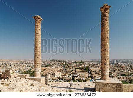 URFA, TURKEY - AUGUST 19, 2008: Tourists admire the cityscape under ancient columns in citadel of Urfa. The famous dual columns were built by the Abbasids in 814 AD