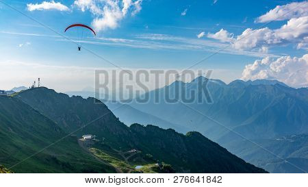 Glider In Blue Cloudy Sky Over The Green Mountain