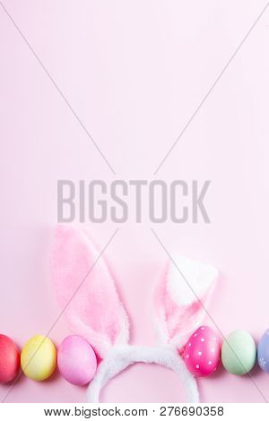 Easter Rabbit Flaffy Ears And Colored Easter Colored Eggs On Pink Background With Copy Space