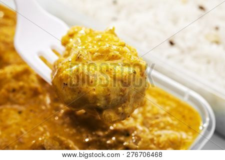 Fork Lifting Piece Of Indian Take Away Meal Of Chicken Bhoona Or Bhuna Curry With Indian Pilau Rice 
