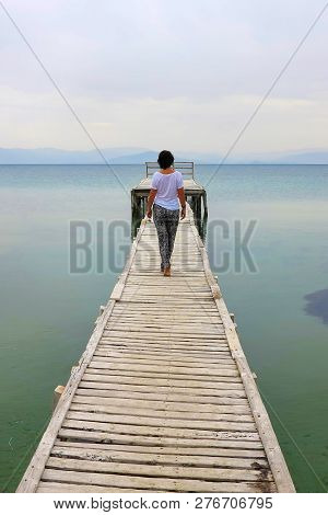 Woman From The Back Goes Along The Pier, Messonghi, Corfu, Greece
