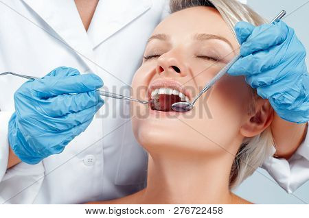 Dentist Examining A Patient's Teeth In The Dentis.