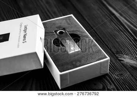 UKRAINE, ROVNO - ON DECEMBER 2: Ledger hardware wallet for cryptocurrency on a wood background