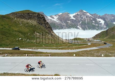 Grossglockner, Austria - August 7, 2017: Cyclists Climbing Mountain Pass By Alpine Road Through Vall