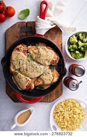 Cooked Chicken Breast Seared In A Cast Iron Skillet With Creamy Pan Sauce
