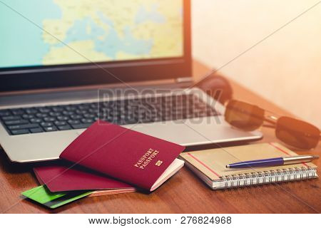 On The Laptop Desk, Two Foreign Passports, Credit Cards, A Notebook With A Pen And Glasses