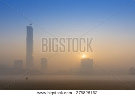 Beautiful Image Of Sunrise At Kolkata Maidan In A Foggy Winter Morning. Sunrises At The Horizon Abov