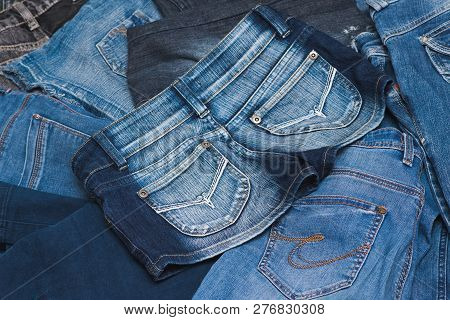 High Angle View Of Rear Pockets Of Three Different Styles Of Blue Jeans In Various Color Washes