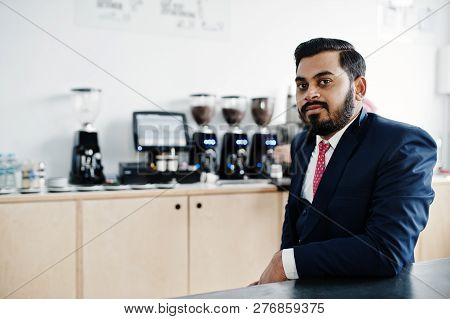Stylish Beard Indian Business Man On Suit Sitting At Cafe.