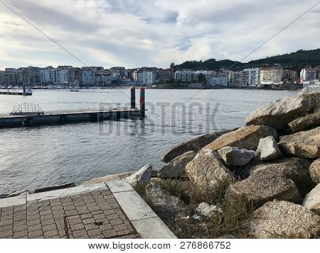 View Of The Harbour From Over Some Rocks On Galicia Spain